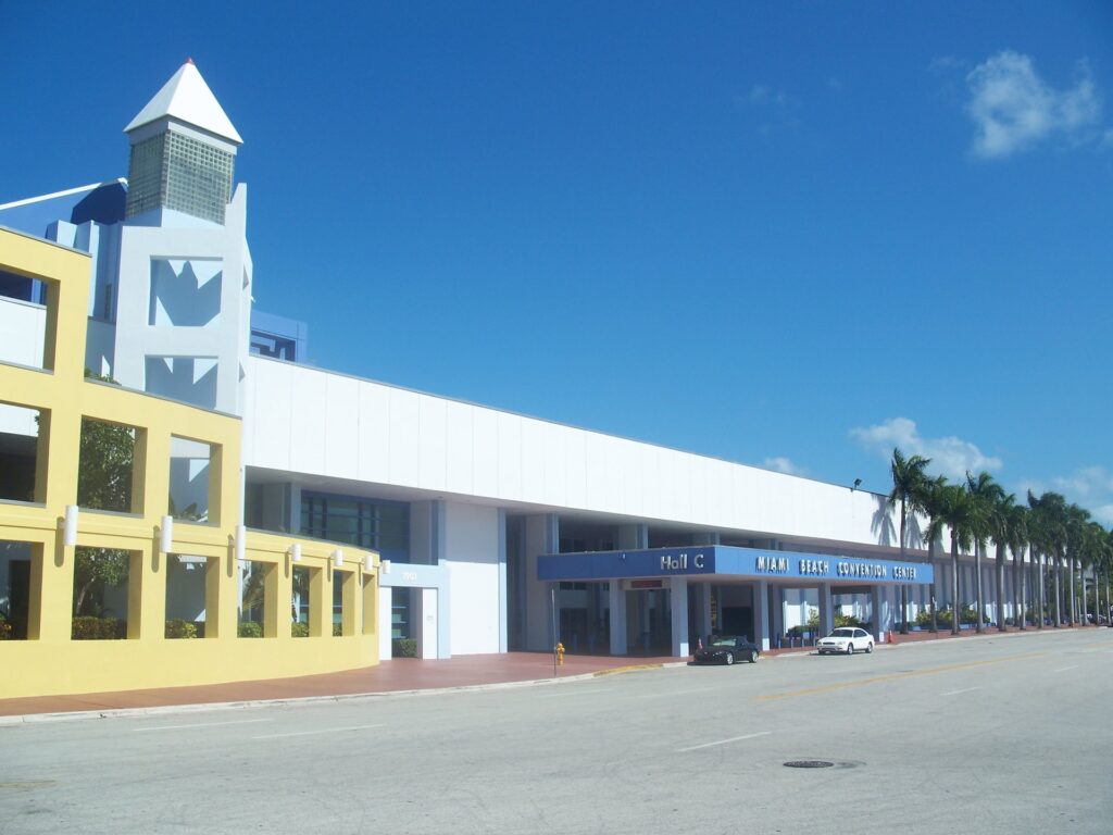 Miami Art Week 2026: aerial view of the Miami Beach Convention Center with the Hall C entrance sign and the palm-lined approach at 1901 Convention Center Drive