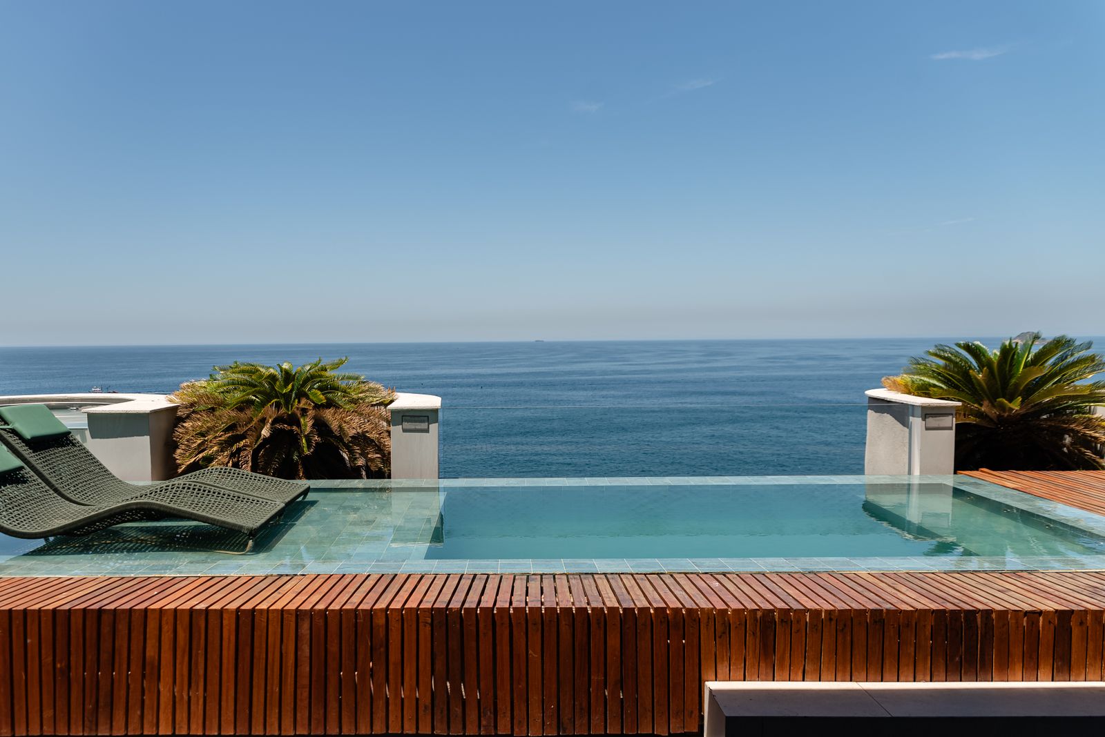 Infinity pool with lounge chairs overlooking the ocean at a luxury resort