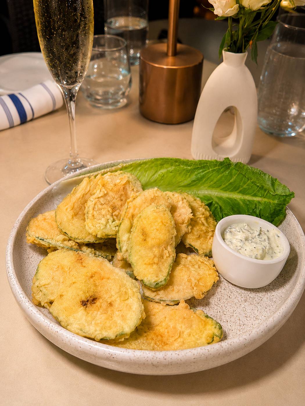 Golden fried zucchini chips with tzatziki and a glass of sparkling wine at Santorini by Georgios
